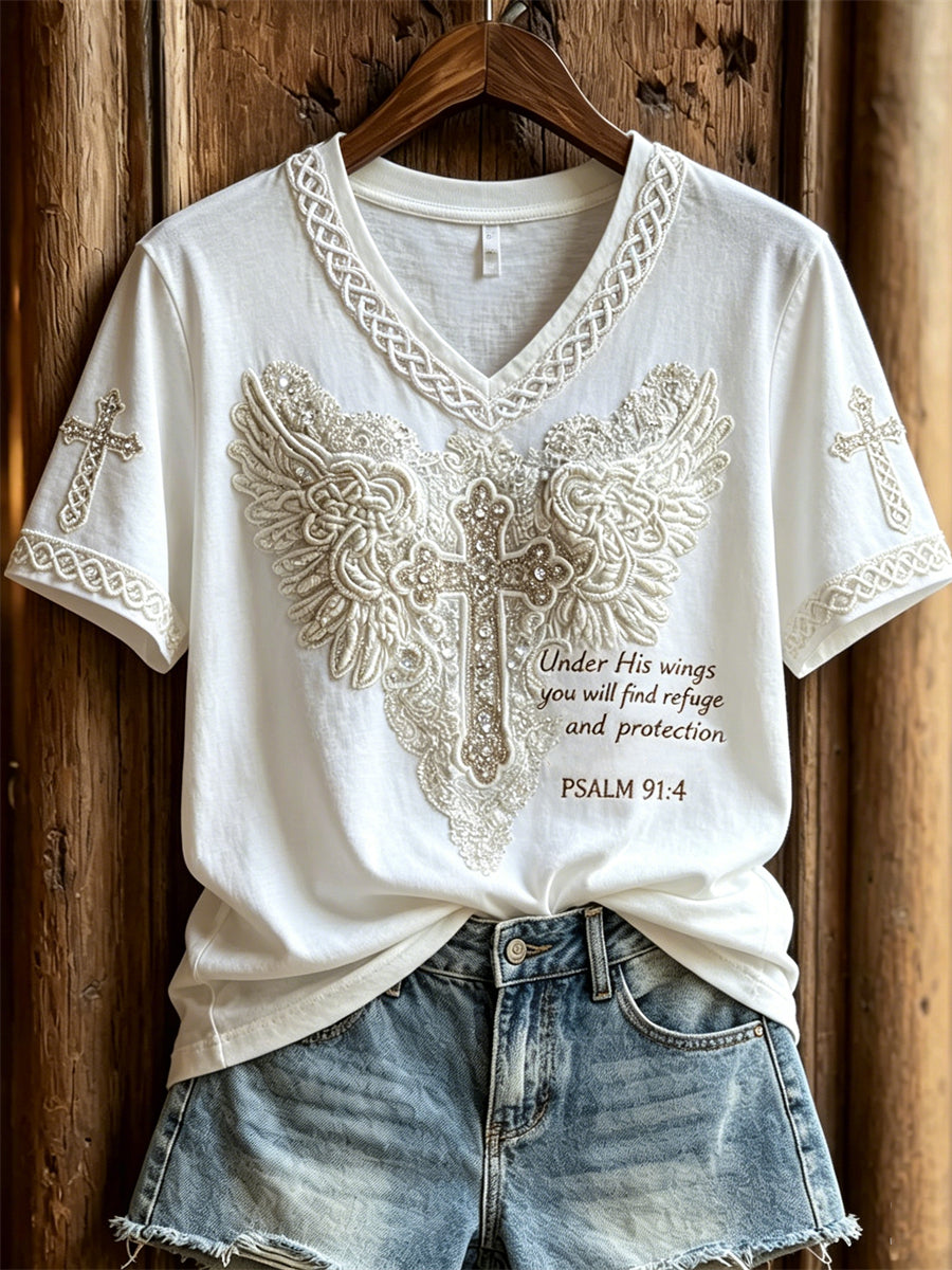 Kvinnlig T-shirt med korta ärmarna och tryck: ”Under Hans Vingar Skall Du Finna Fristad” – Kors med vingar